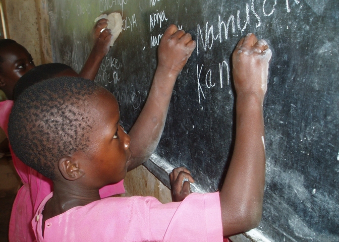 Girls learning to write in a rural school in Uganda